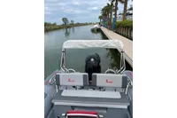 2022 Marshall M4 Touring boat docked on a calm canal with palm trees.