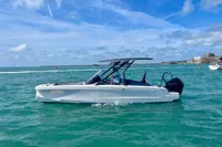 2022 Axopar 22 T-Top boat cruising on clear blue water under a sunny sky.