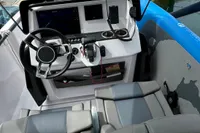 2022 Axopar 22 T-Top boat cockpit with steering wheel, controls, and seating.