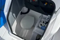 2022 Axopar 22 T-Top boat interior with compact toilet and storage compartments.