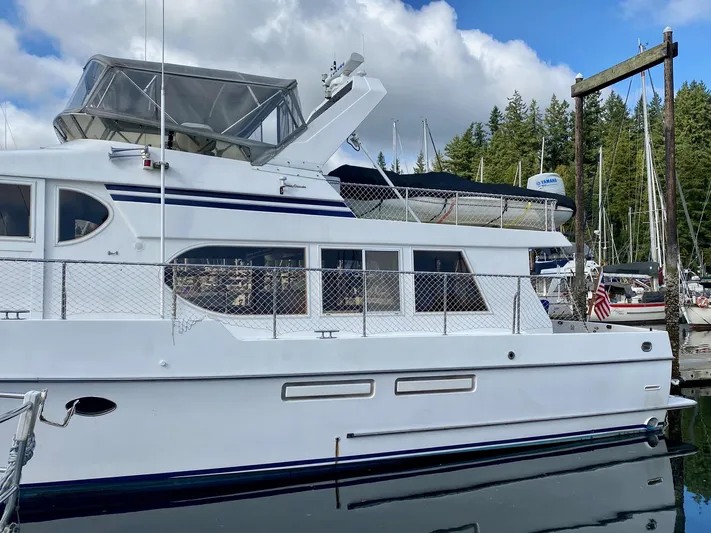 First Light Yacht Photos Pics 1999 Ocean Alexander 510 Pilothouse docked, surrounded by trees.