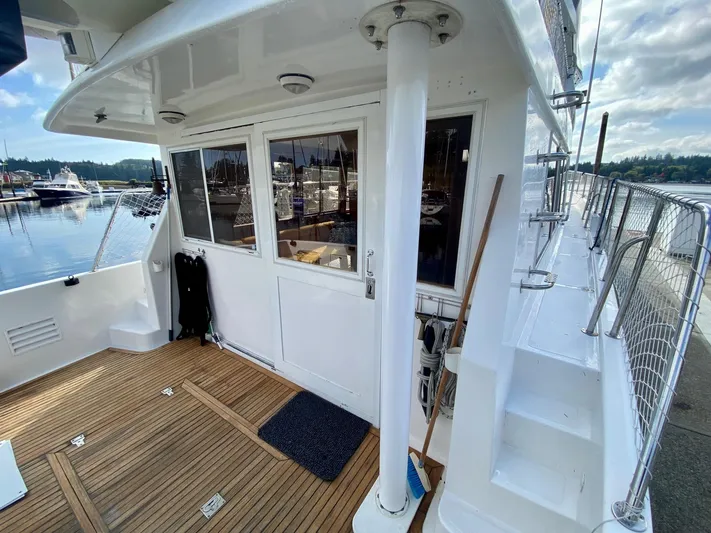 First Light Yacht Photos Pics Ocean Alexander 510 Pilothouse 1999, exterior deck view with wood flooring and marina background.