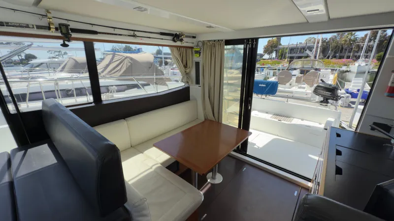  Yacht Photos Pics Interior of 2016 Jeanneau Velasco 37F yacht with seating and table, marina view.
