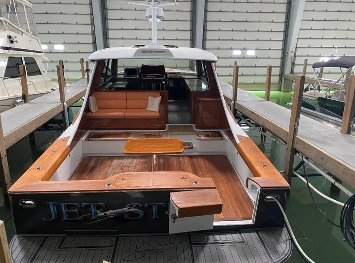 Jet Stream Yacht Photos Pics 2018 Spencer Yachts JET BOAT in a storage facility, showcasing its spacious deck and seating area.