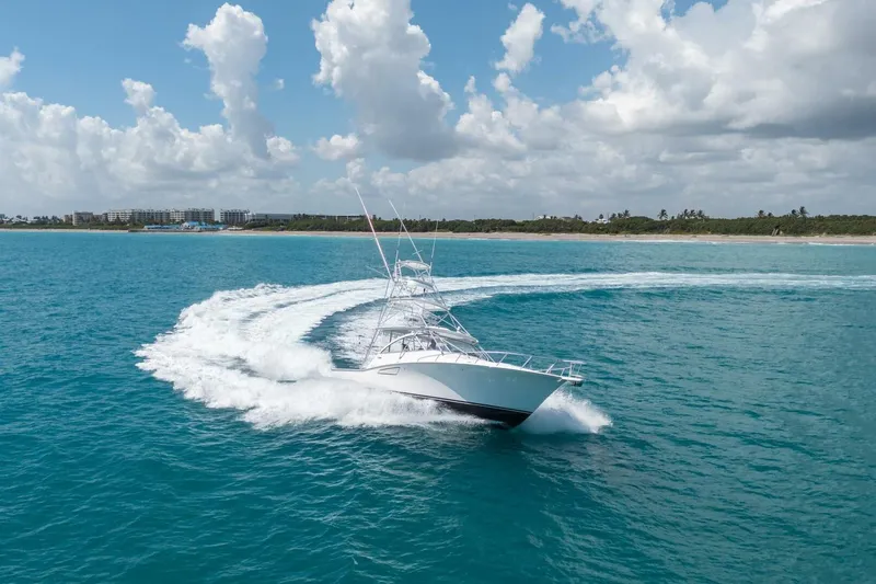 Big Hit Yacht Photos Pics 2020 Cabo 40 Express yacht cruising on clear blue ocean under a partly cloudy sky.