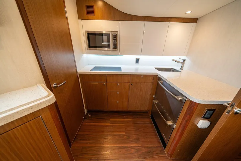 Big Hit Yacht Photos Pics Modern kitchen interior of 2020 Cabo 40 Express yacht with wood cabinetry and appliances.