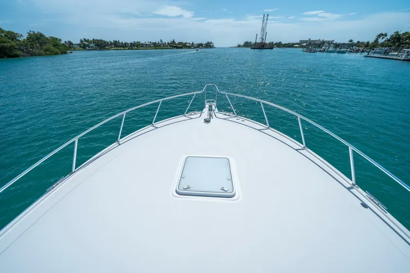 Big Hit Yacht Photos Pics Bow view of 2020 Cabo 40 Express yacht cruising on clear blue waters.
