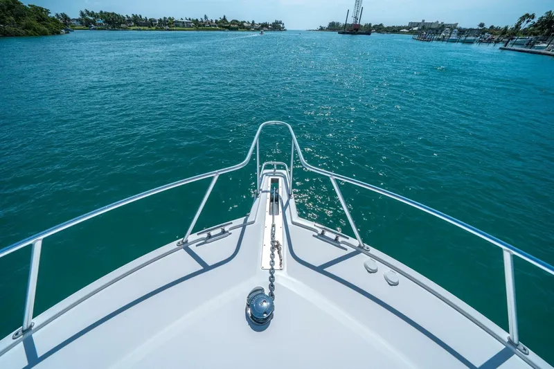 Big Hit Yacht Photos Pics Bow view of 2020 Cabo 40 Express yacht cruising on clear blue waters.