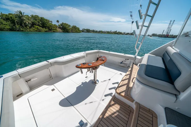 Big Hit Yacht Photos Pics 2020 Cabo 40 Express boat deck with seating, fishing rod holders, and scenic water view.