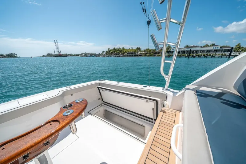 Big Hit Yacht Photos Pics 2020 Cabo 40 Express boat deck with fishing rod holders, overlooking serene blue waters.