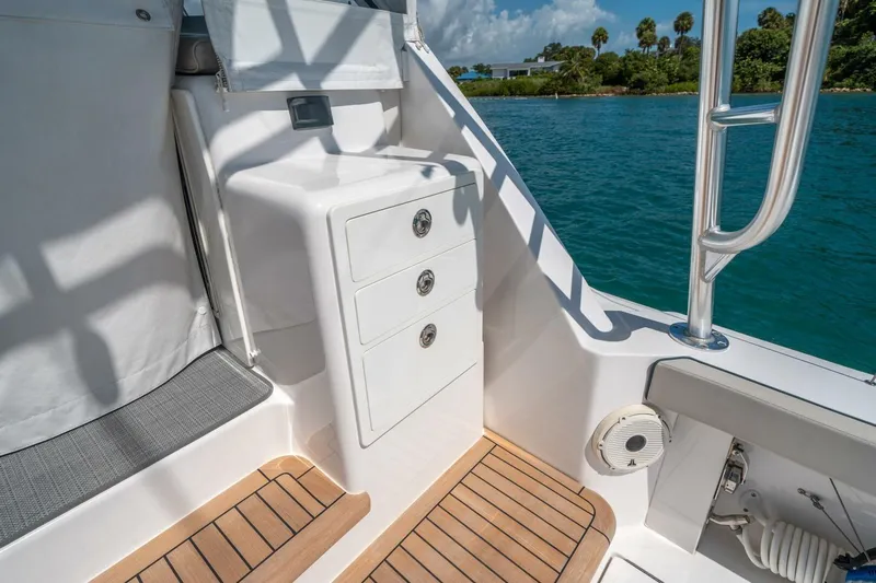 Big Hit Yacht Photos Pics 2020 Cabo 40 Express boat interior with storage drawers and teak flooring by the water.