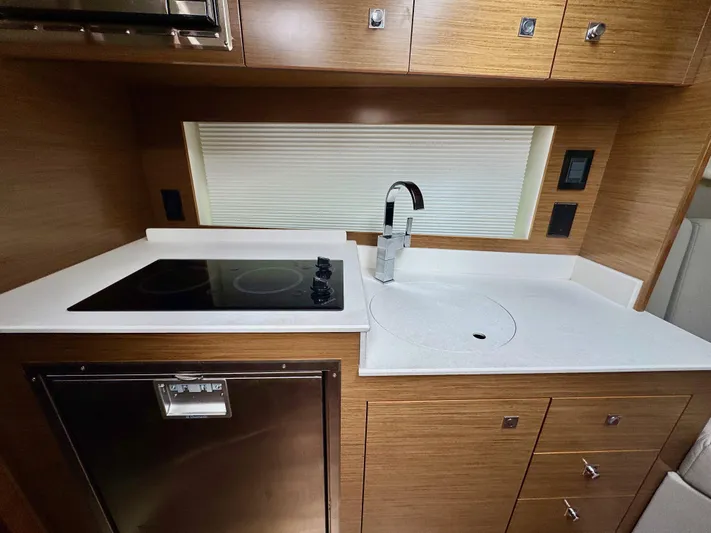 Determination Yacht Photos Pics Modern kitchen in 2020 Cruisers Yachts 39 Express Coupe with stovetop and sink.
