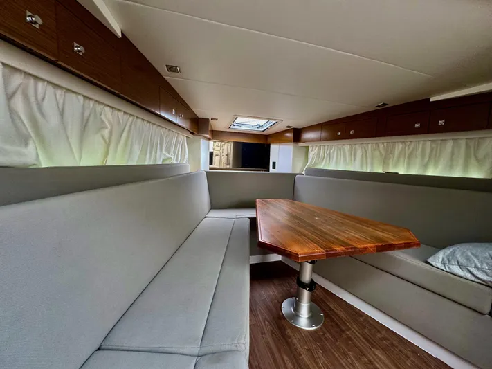 Determination Yacht Photos Pics Interior of 2020 Cruisers Yachts 39 Express Coupe with modern seating and wooden table.
