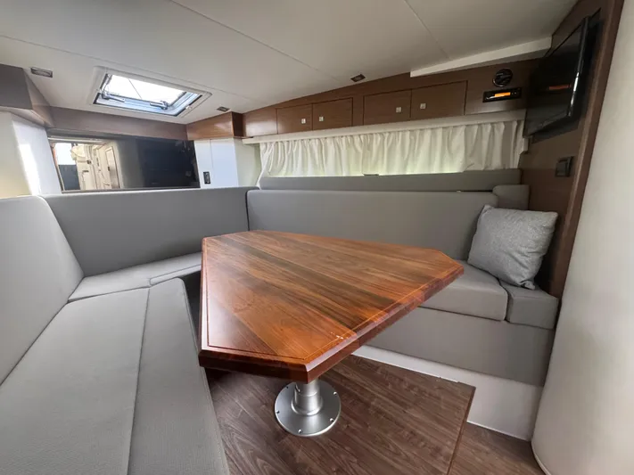 Determination Yacht Photos Pics Interior of 2020 Cruisers Yachts 39 Express Coupe with wooden table and gray seating.