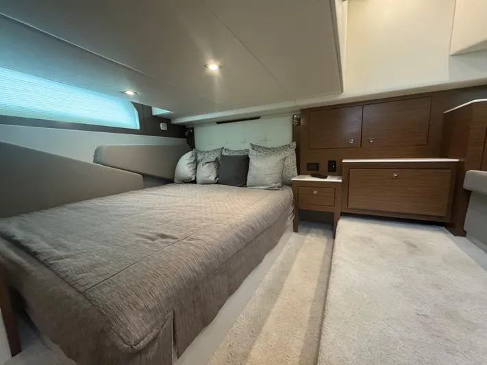 Determination Yacht Photos Pics Luxurious cabin interior of 2020 Cruisers Yachts 39 Express Coupe with cozy bed and wooden cabinetry.