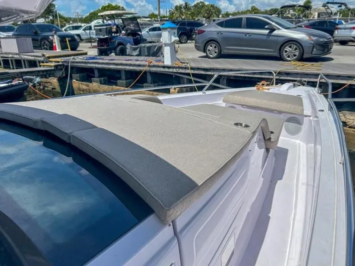  Yacht Photos Pics 2024 Axopar 45 XC Cross Cabin boat docked, featuring cushioned deck seating.