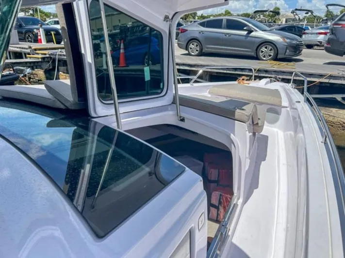  Yacht Photos Pics 2024 Axopar 45 XC Cross Cabin boat docked, showcasing sleek design and spacious deck.