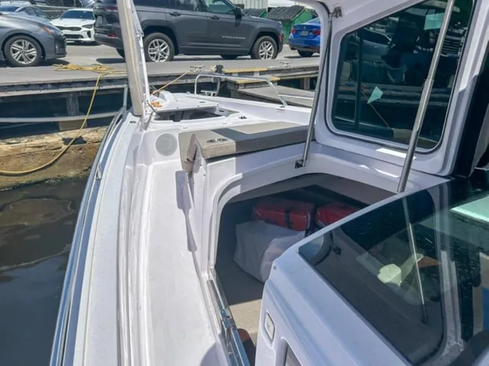  Yacht Photos Pics 2024 Axopar 45 XC Cross Cabin boat docked, showcasing sleek design and spacious deck.