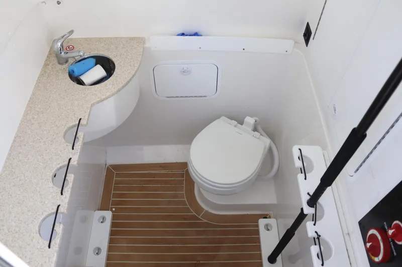  Yacht Photos Pics 2020 Regulator 31 boat bathroom with sink, toilet, and wooden floor.