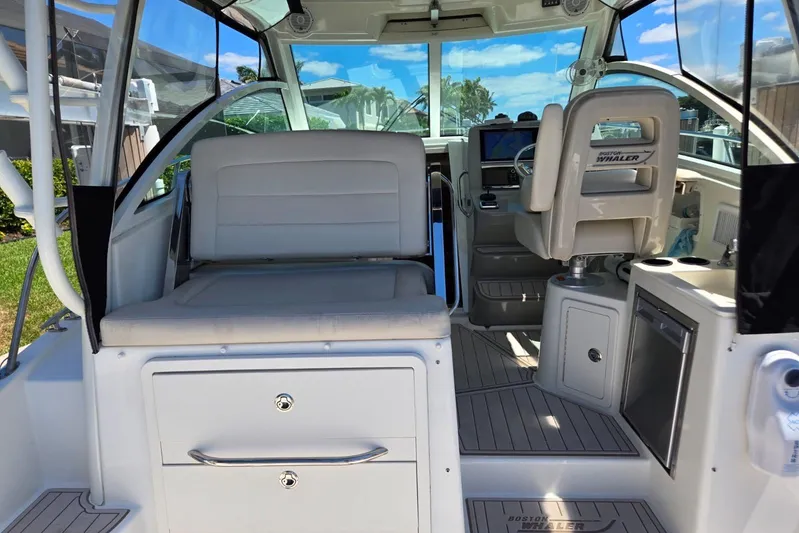  Yacht Photos Pics 2016 Boston Whaler 315 Conquest interior with seating and helm, showcasing luxury and functionality.