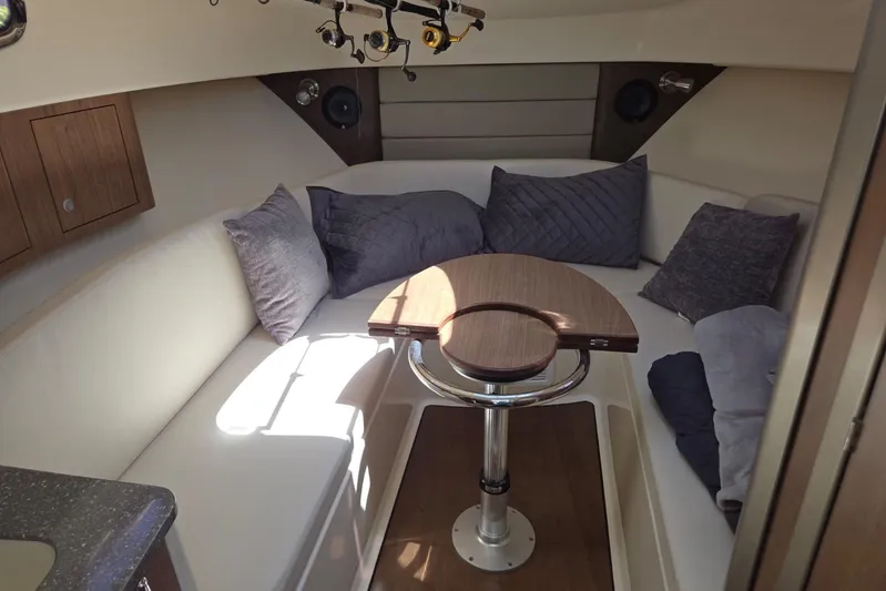  Yacht Photos Pics Interior of 2016 Boston Whaler 315 Conquest, featuring cozy seating and a wooden table.