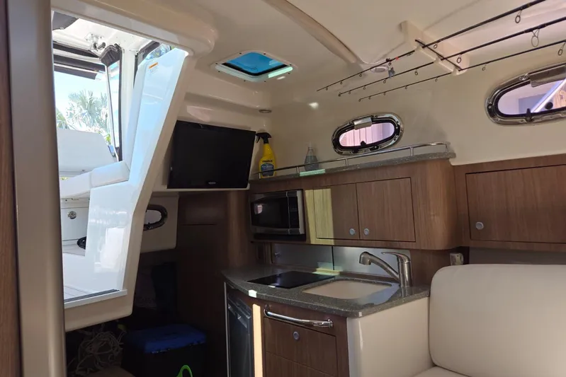  Yacht Photos Pics Interior of 2016 Boston Whaler 315 Conquest boat with kitchenette and seating area.