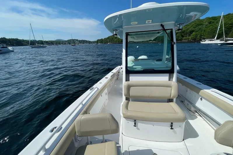  Yacht Photos Pics 2019 Everglades 273 Center Console boat on a scenic lake with surrounding sailboats.
