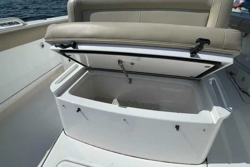  Yacht Photos Pics Open storage compartment on 2019 Everglades 273 Center Console boat, with beige seating.