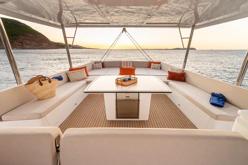  Yacht Photos Pics Luxurious Bali 5.8 yacht deck with seating, table, and ocean view at sunset, 2026 model.