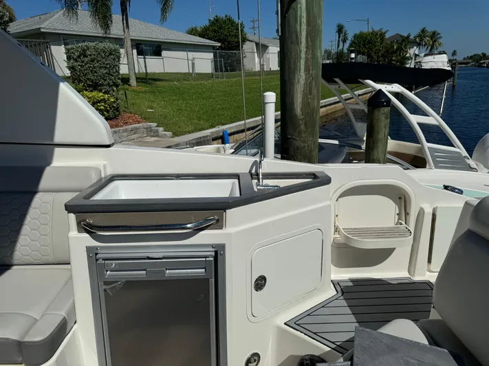  Yacht Photos Pics 2020 Sea Ray SDX 290 Outboard boat interior with sink and seating by the dock.