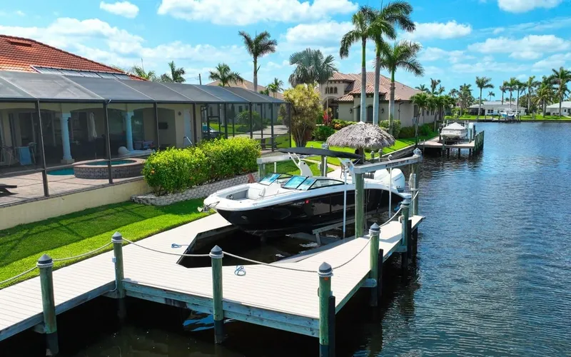  Yacht Photos Pics 2020 Sea Ray SDX 290 Outboard docked by waterfront homes, palm trees, and clear skies.