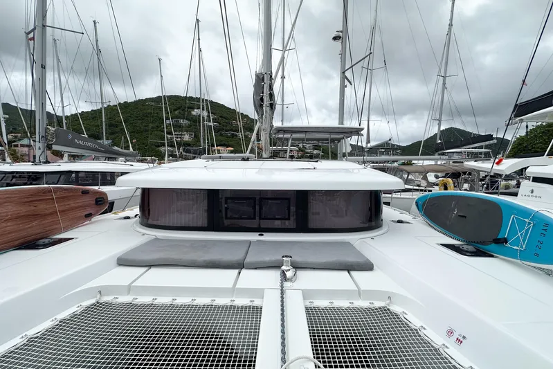 Island Riff Yacht Photos Pics 2025 Lagoon 42 catamaran docked, featuring paddleboards and lush hillside backdrop.