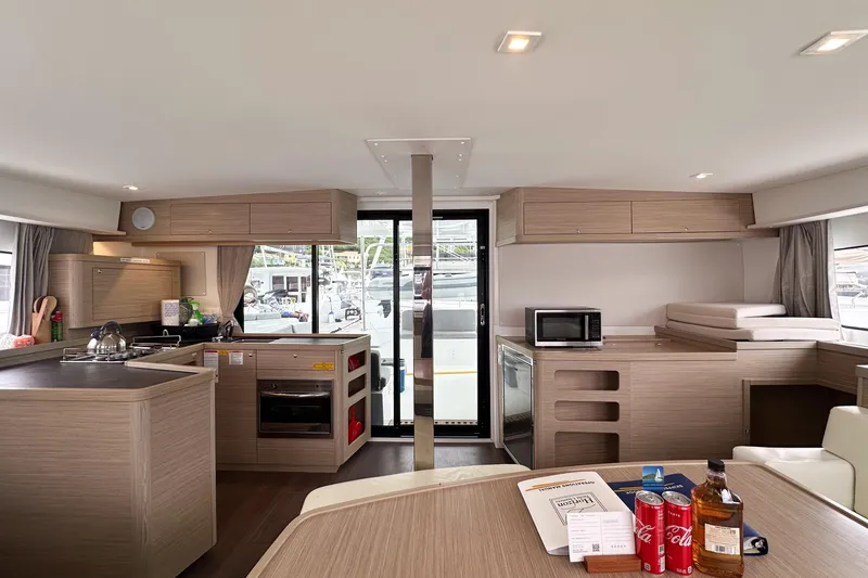 Island Riff Yacht Photos Pics Modern interior of 2025 Lagoon 42 catamaran with kitchen and lounge area.