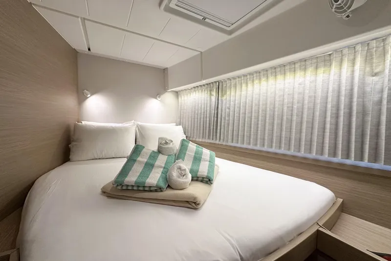 Island Riff Yacht Photos Pics Luxurious cabin interior of 2025 Lagoon 42 yacht with cozy bed and elegant decor.