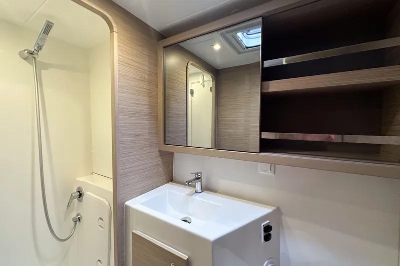 Island Riff Yacht Photos Pics Modern bathroom in 2025 Lagoon 42 yacht with shower, sink, and storage shelves.