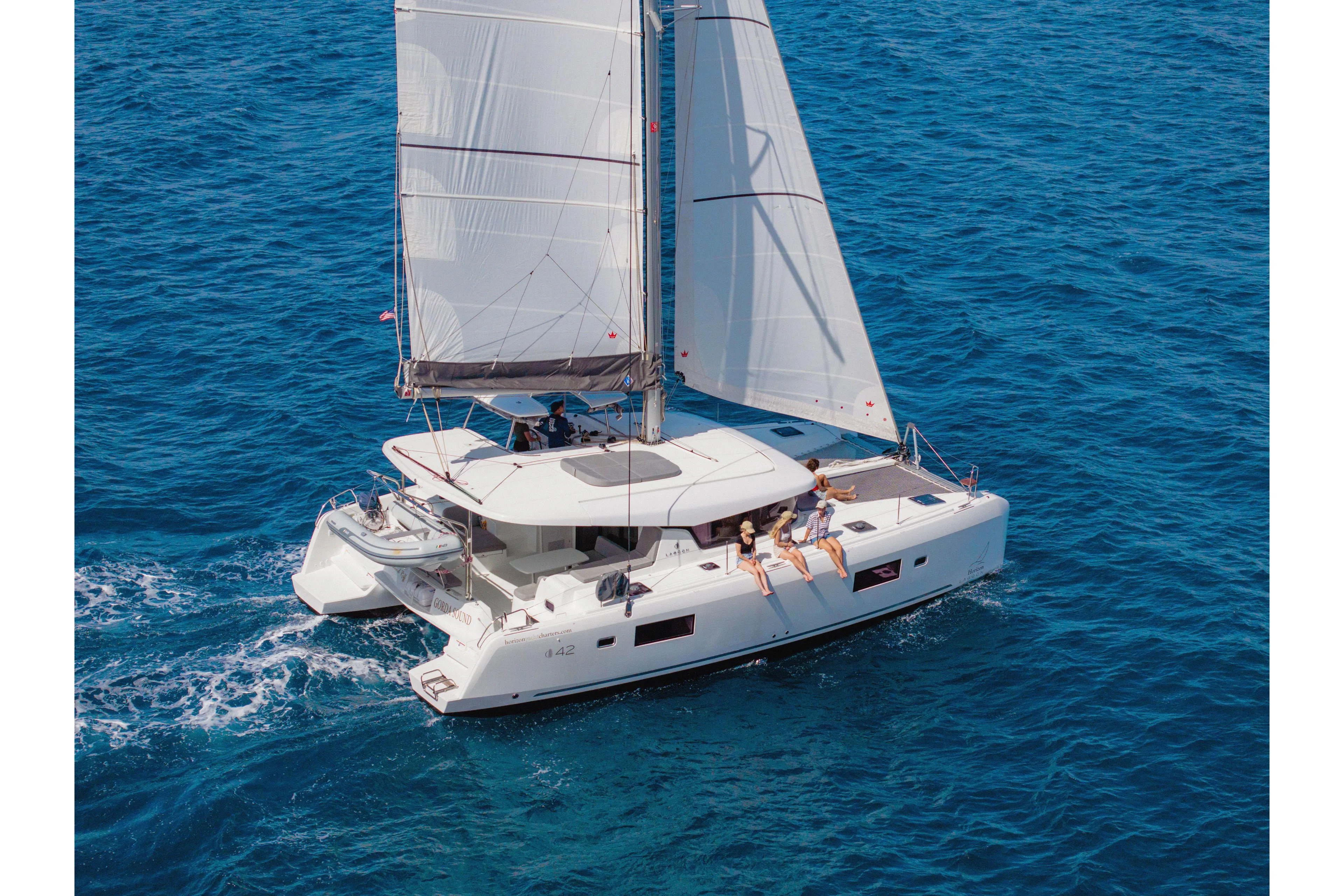 Island Riff Yacht Photos Pics 2025 Lagoon 42 catamaran sailing on clear blue ocean waters.