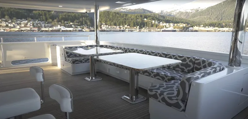 Jackpot Yacht Photos Pics Outdoor seating area on Christensen 2020 yacht with scenic waterfront view.
