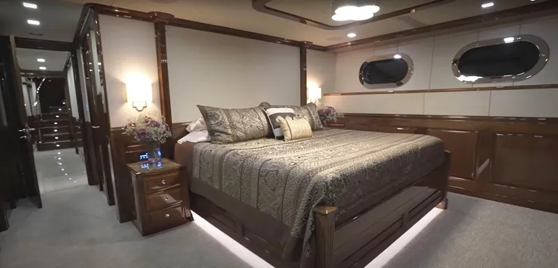 Jackpot Yacht Photos Pics Luxurious bedroom in Christensen Model Year 2020 yacht, featuring elegant decor and ambient lighting.