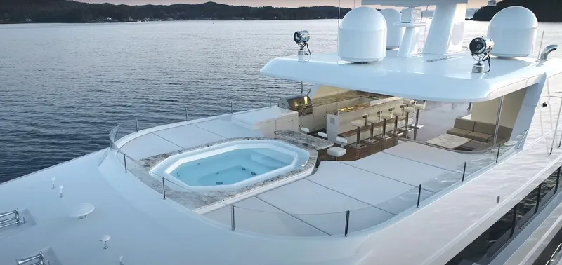 Jackpot Yacht Photos Pics Luxurious Christensen 2020 yacht with hot tub and bar on the deck, cruising on serene waters.