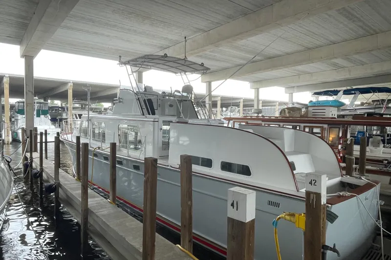 Mnm Yacht Photos Pics 1958 Huckins Seafarer yacht docked in a covered marina, showcasing classic design.