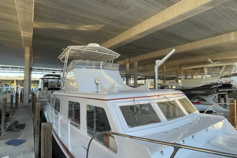 Mnm Yacht Photos Pics 1958 Huckins Seafarer yacht docked in a covered marina, showcasing classic design.