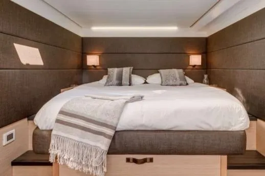 Lena Yacht Photos Pics Luxurious bedroom interior of 2017 Lagoon 63 Power yacht with elegant bedding and soft lighting.