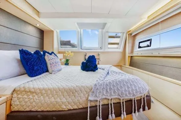 Lena Yacht Photos Pics Luxurious bedroom interior of 2017 Lagoon 63 Power yacht with elegant decor and large windows.