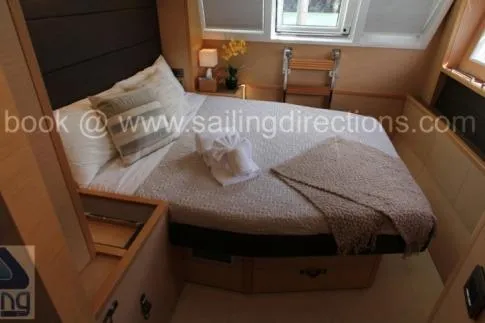 Lena Yacht Photos Pics Cozy cabin interior of 2017 Lagoon 63 Power yacht with bed and window view.