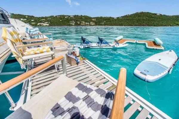 Lena Yacht Photos Pics Luxurious Lagoon 63 Power yacht deck with chairs, paddleboard, and turquoise water view, 2017 model.