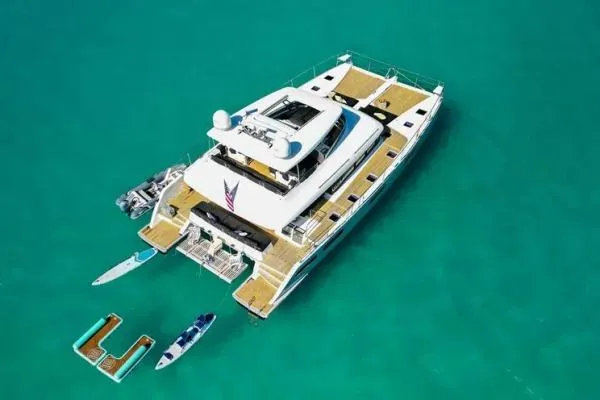 Lena Yacht Photos Pics Aerial view of 2017 Lagoon 63 Power yacht with paddleboards in turquoise water.