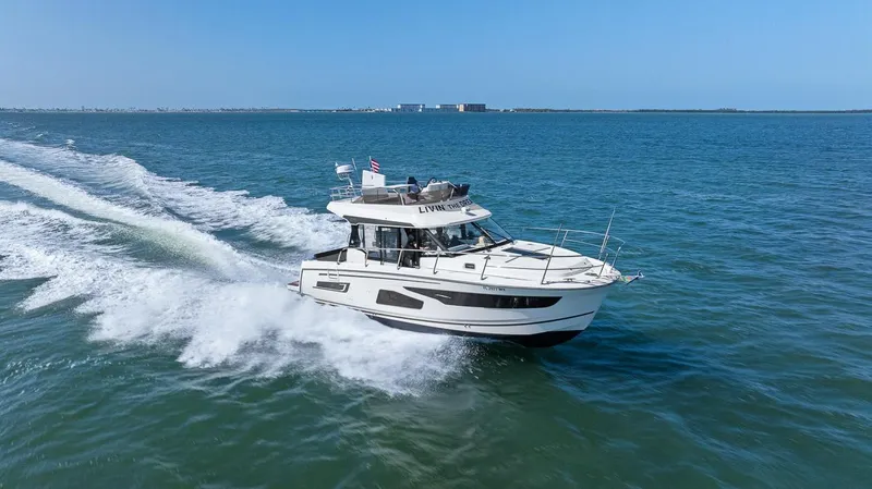 Trinity Yacht Photos Pics 2020 Jeanneau NC 1095 Fly cruising on open water, showcasing sleek design and performance.