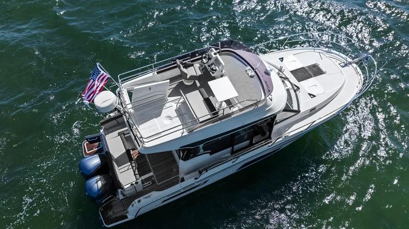 Trinity Yacht Photos Pics 2020 Jeanneau NC 1095 Fly boat cruising on open water, aerial view.