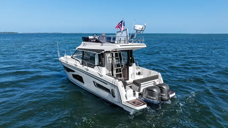 Trinity Yacht Photos Pics 2020 Jeanneau NC 1095 Fly cruising on open water with dual outboard engines.
