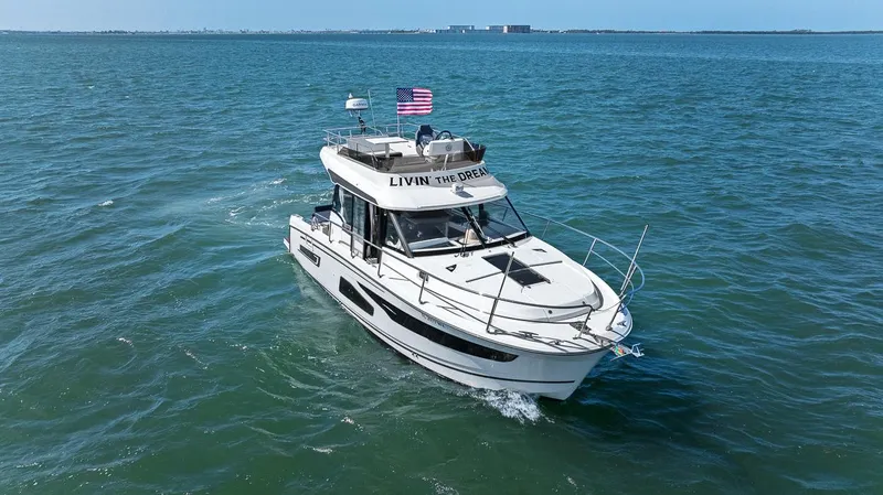 Trinity Yacht Photos Pics 2020 Jeanneau NC 1095 Fly cruising on open water with American flag.